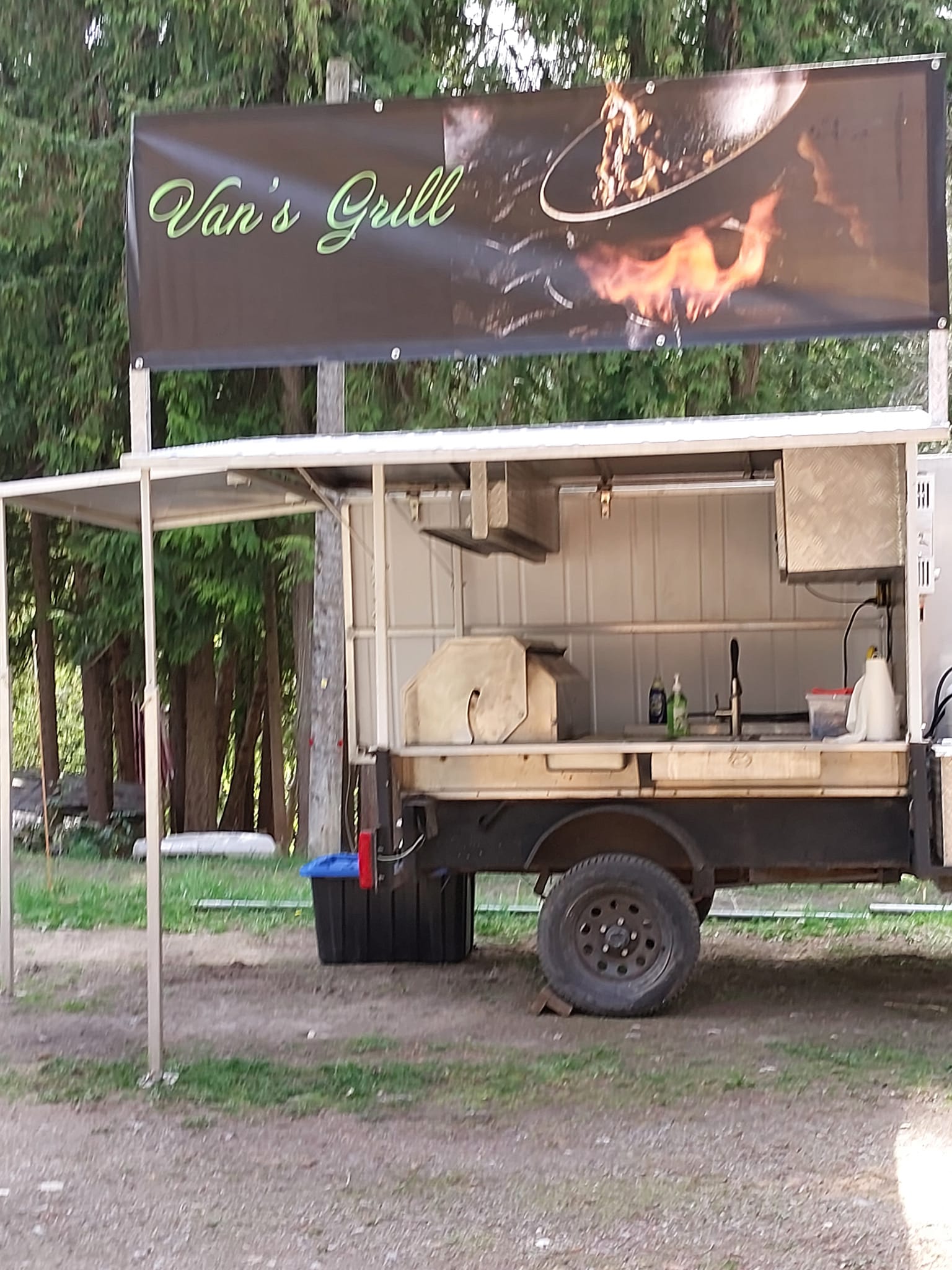 Van’s Grill mobile BBQ trailer with branded banner set up outdoors in the North Shuswap